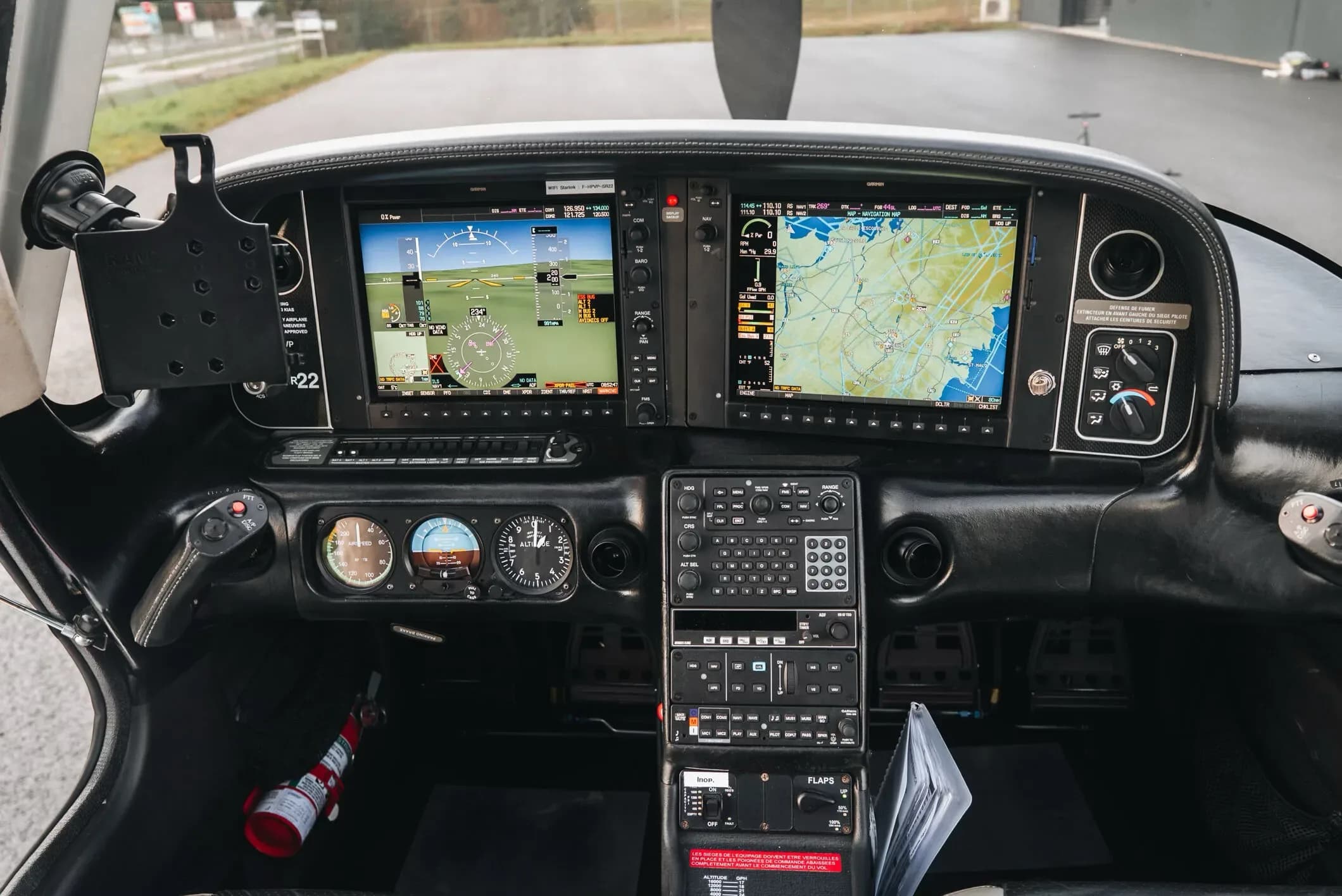 The modern glass cockpit instrument panel of a Cirrus SR22 aircraft with multiple display screens.