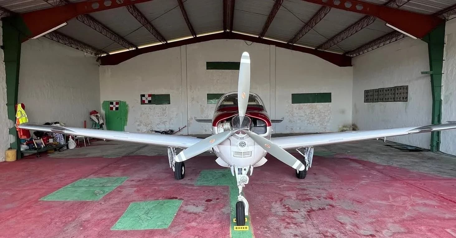 Front view of a Beechcraft Bonanza in a hangar.