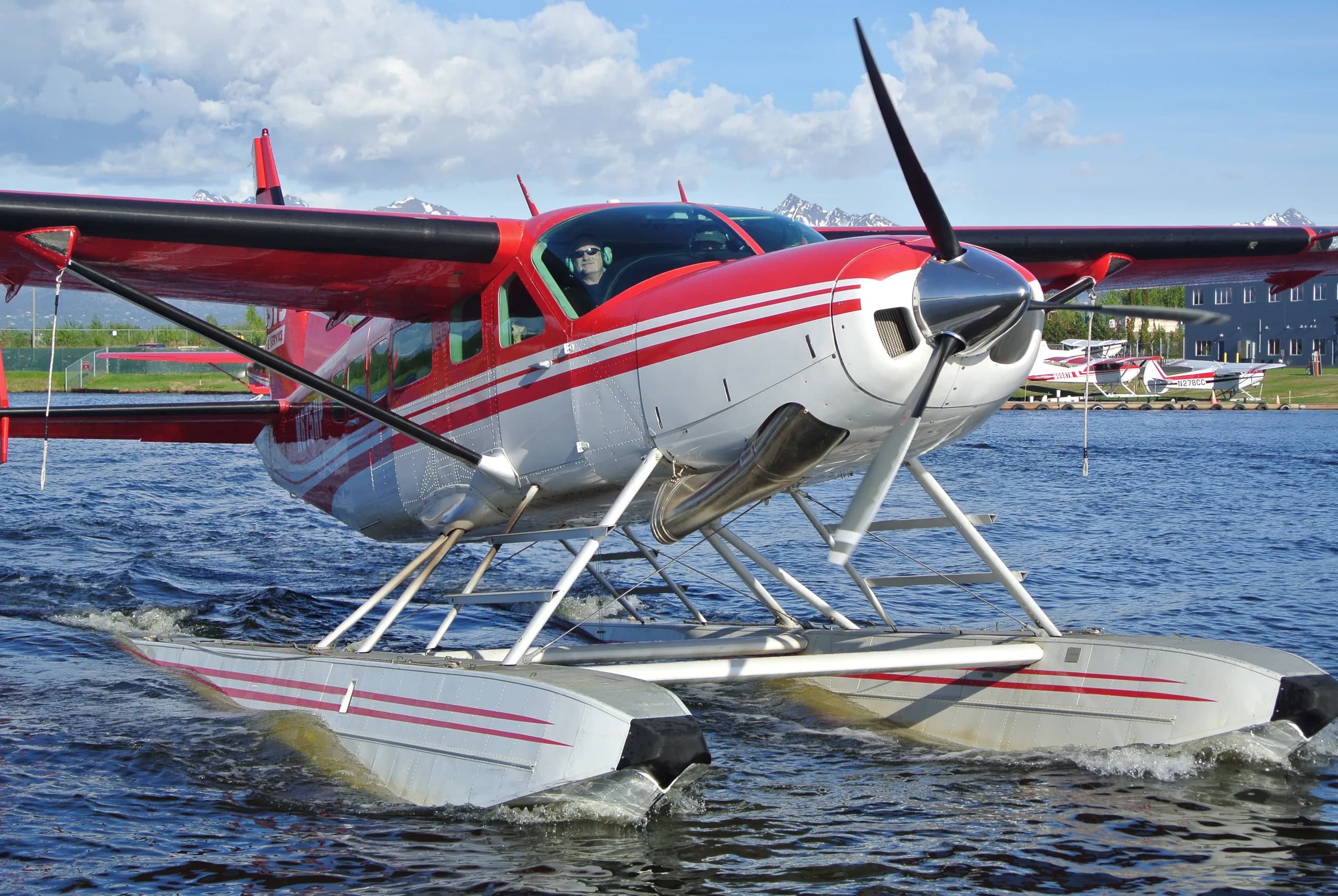 Close up of a red and white floatplane on the water.
