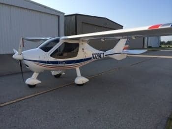 A white CTLS aircraft with blue and red accents parked on the tarmac.