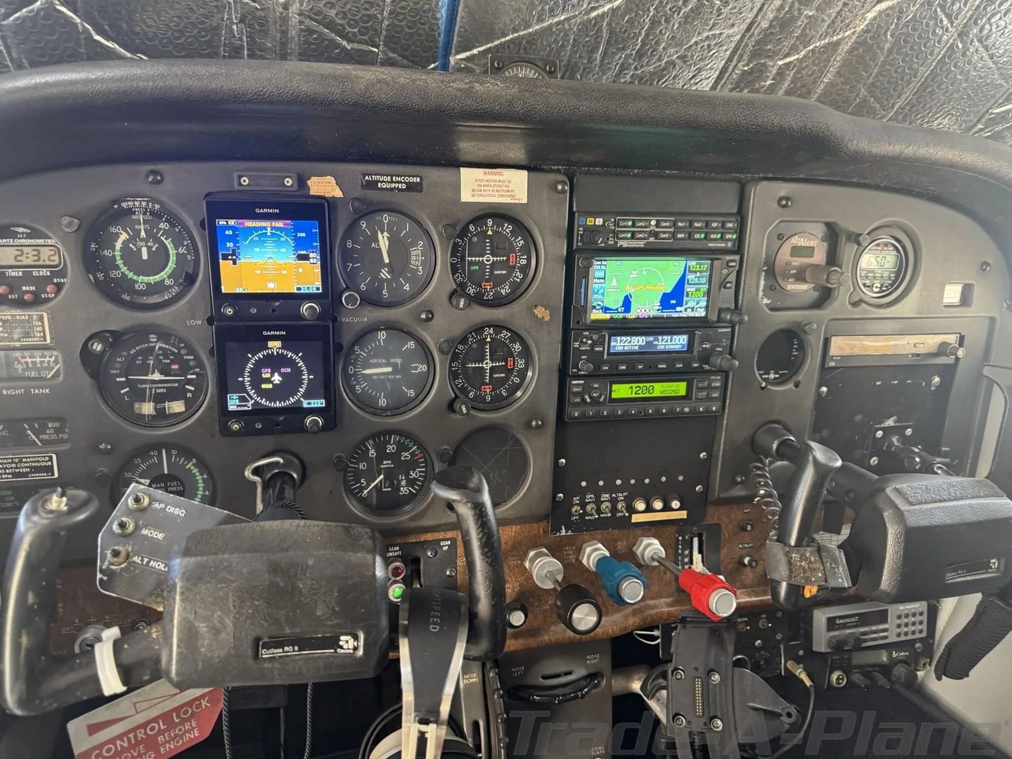 The cockpit instrument panel of the Cessna 182 Skylane, featuring both analog gauges and modern Garmin digital displays.