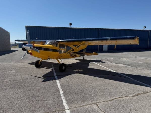 A yellow and blue Maule M-7-235 aircraft with registration N899Z parked on the tarmac.