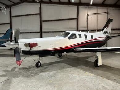 Side view of a TBM 850 aircraft in a hangar.