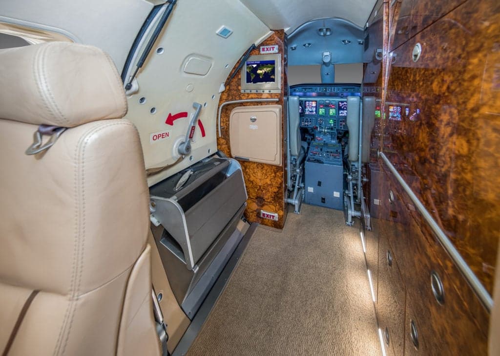 Interior view of the aircraft cabin with tan leather seats.