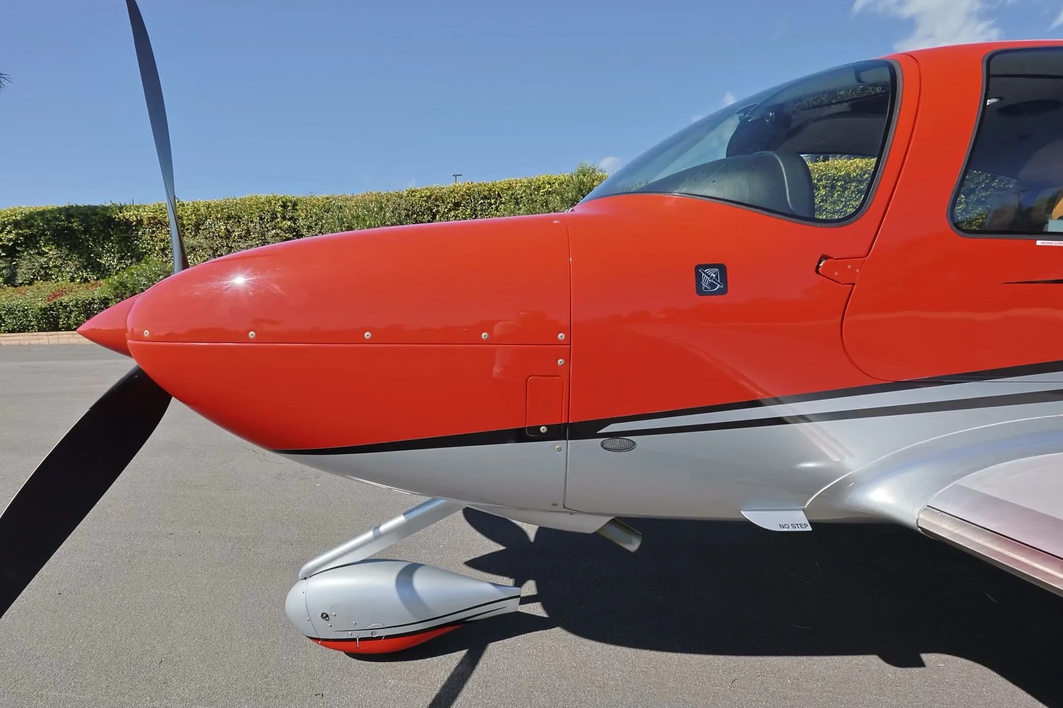 A close-up view of the red nose and propeller of the Cirrus SR22 GTS aircraft.
