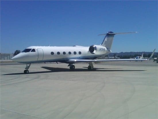 A Gulfstream jet sits on the tarmac on a sunny day.
