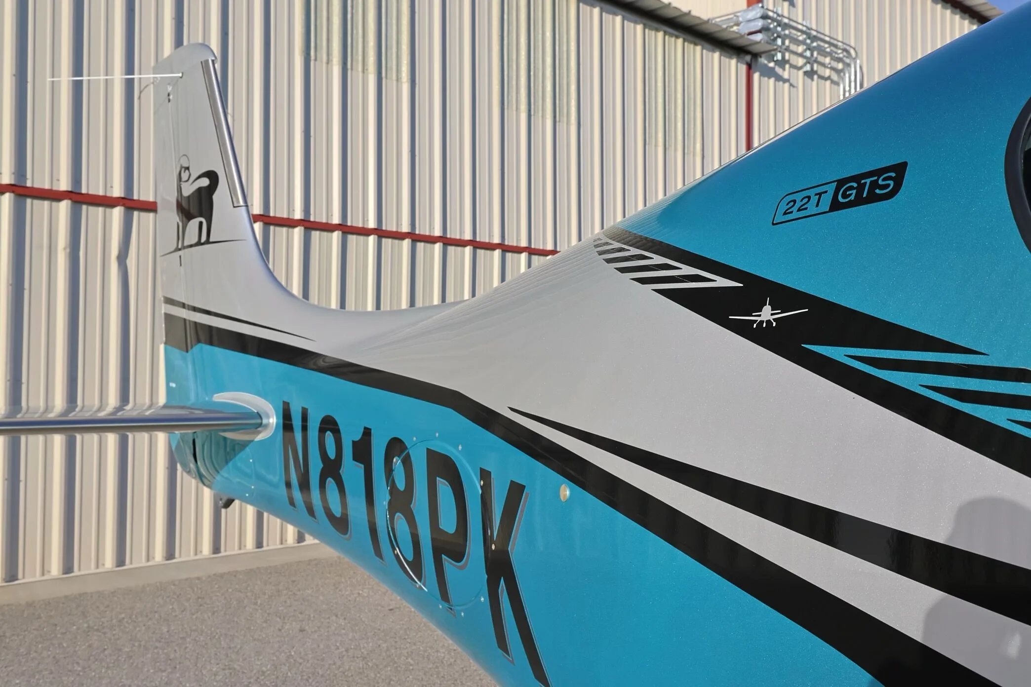 A close-up of the teal and silver fuselage of Cirrus SR22T GTS (N818PK) showing the registration and model designation.