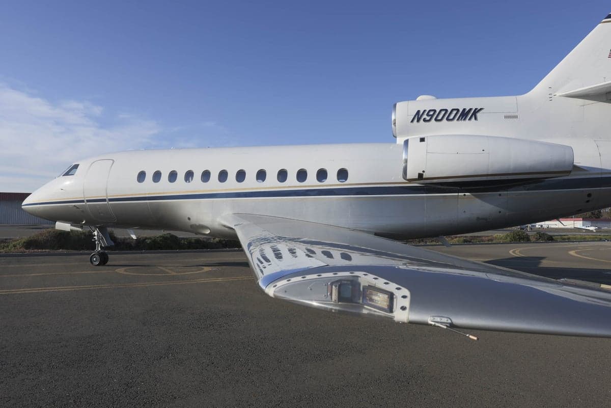 Close-up of the N900MK Falcon aircraft wing and fuselage.