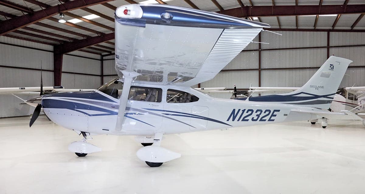 A Cessna Skylane TC aircraft with registration N1232E parked in a hangar, side view.