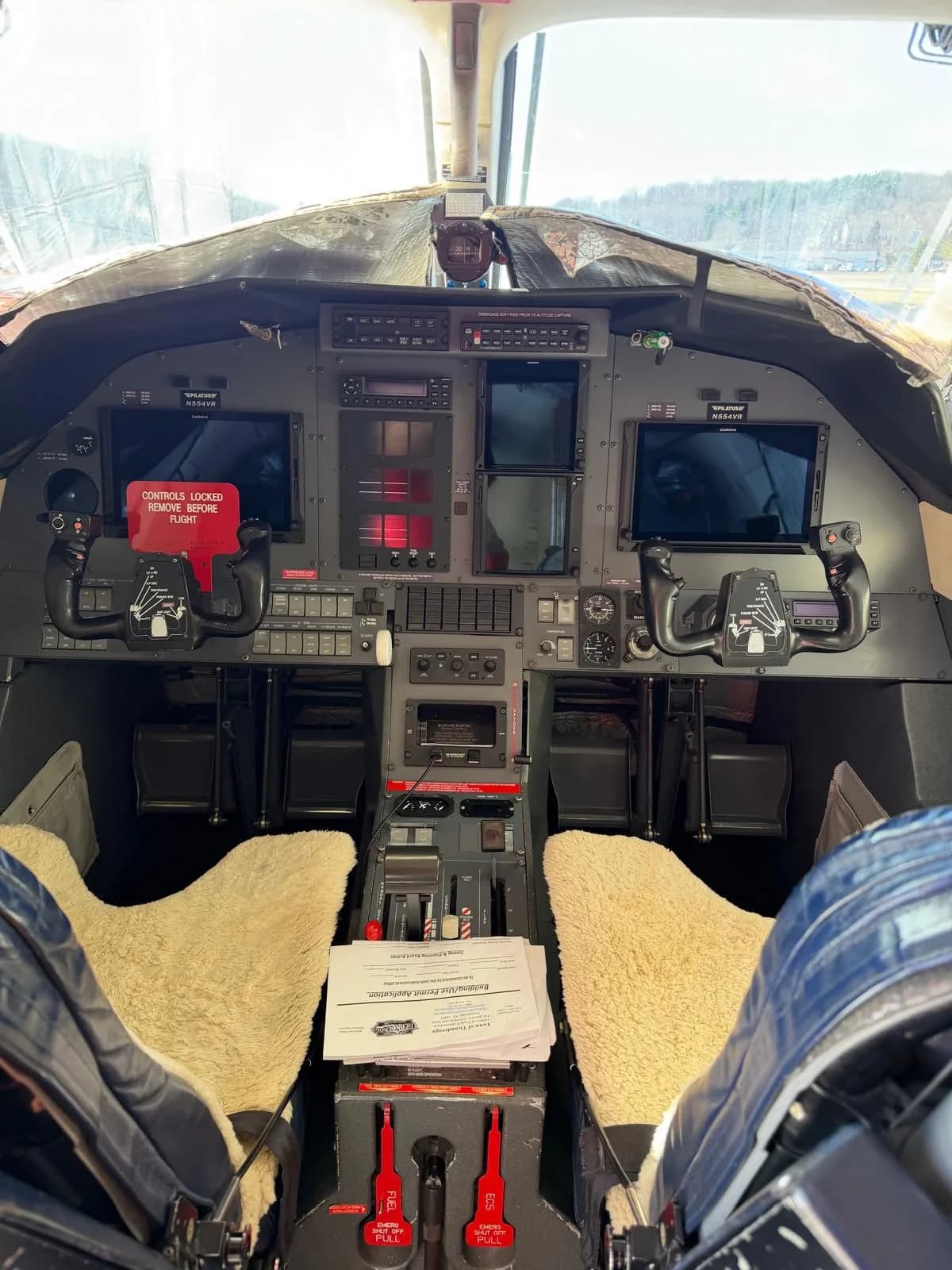 A detailed view of the Pilatus PC-12 cockpit, showing the instrument panel, yokes, and controls.