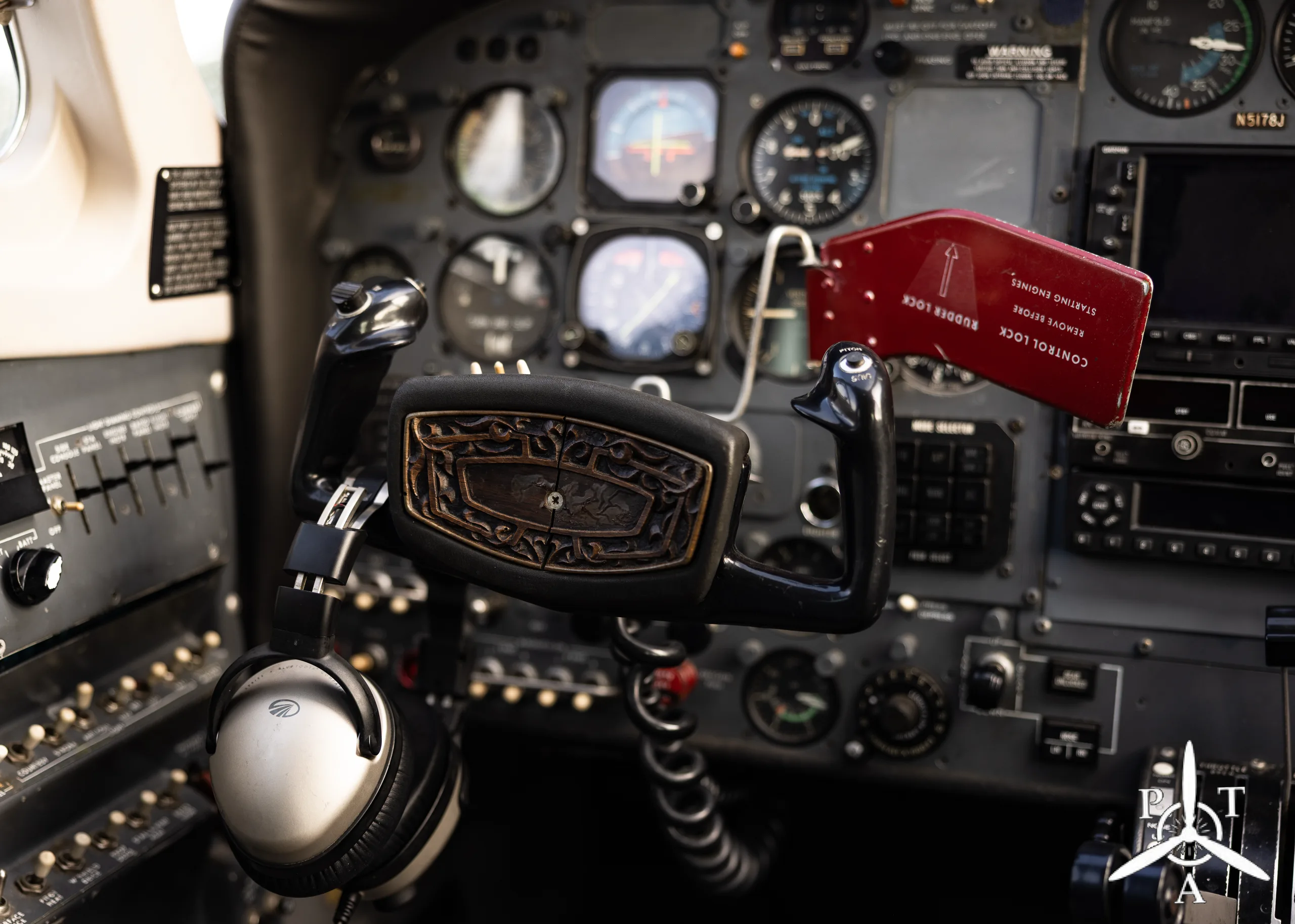 The cockpit instrument panel of an aircraft, showing various gauges, switches, and the control yoke.