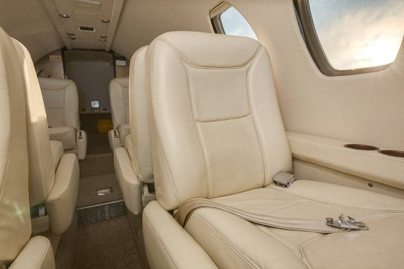 Close-up of the cream-colored leather seats inside the aircraft cabin.
