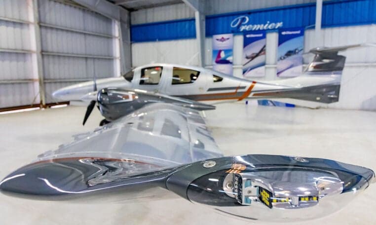 Diamond DA62 aircraft showing the wing and navigation lights in a hangar.