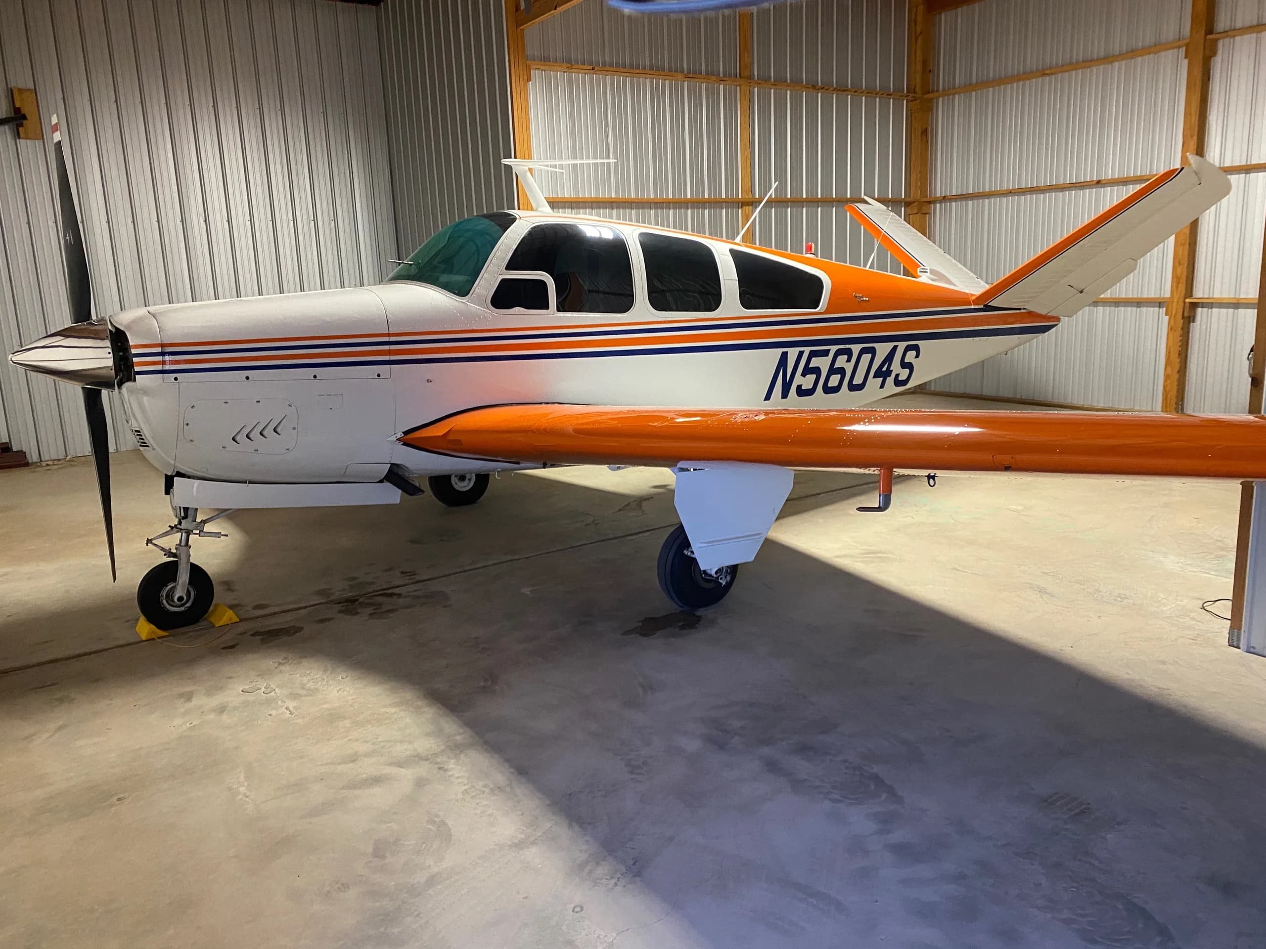 A Beechcraft V35 Bonanza aircraft with registration N5604S parked in a hangar.