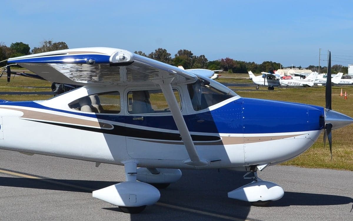 A Cessna 182 Skylane with a blue and white paint scheme on the tarmac.