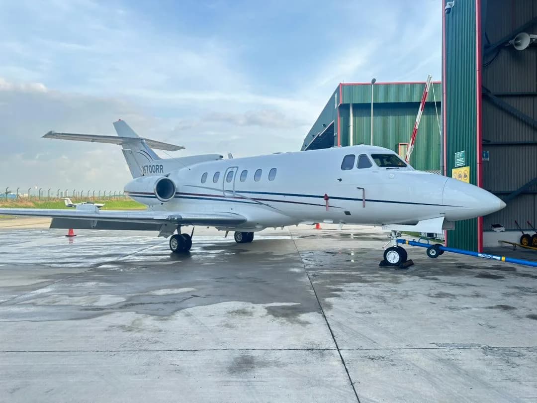 A Hawker 400XP aircraft with registration N700RR is parked outside a hangar.