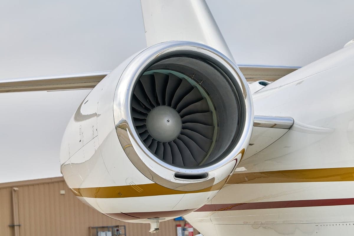 Close up of the engine on a white jet aircraft.