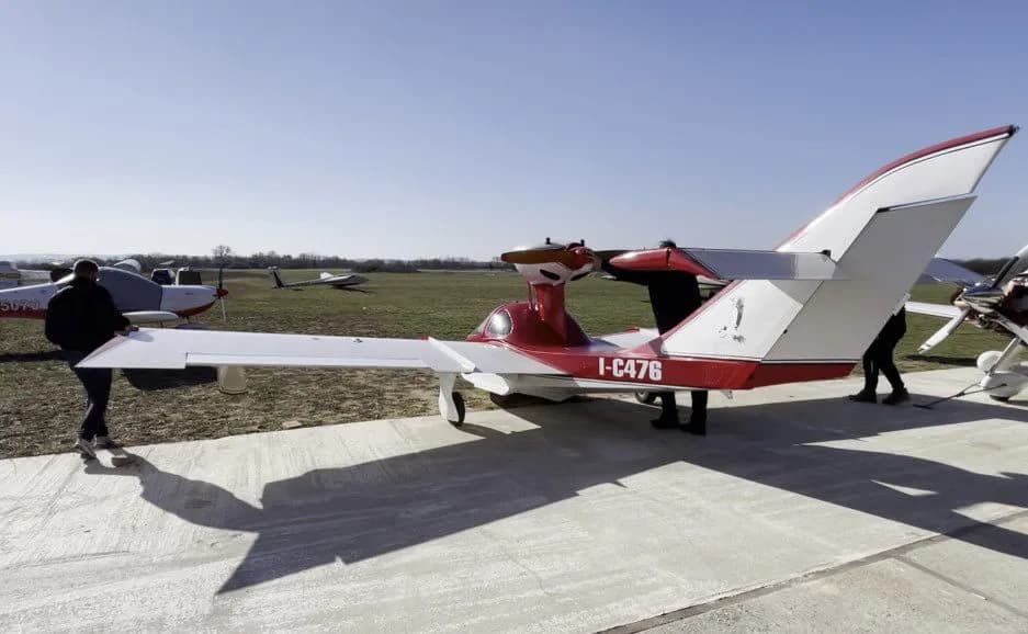 Osprey 2 aircraft with red and white paint scheme on the ground.