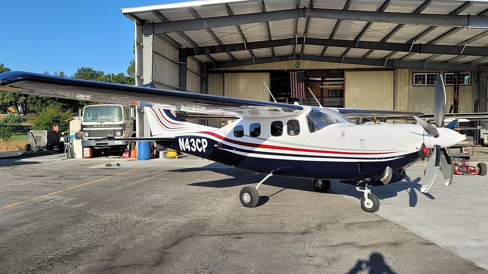 The N43CP aircraft parked in front of a hangar.