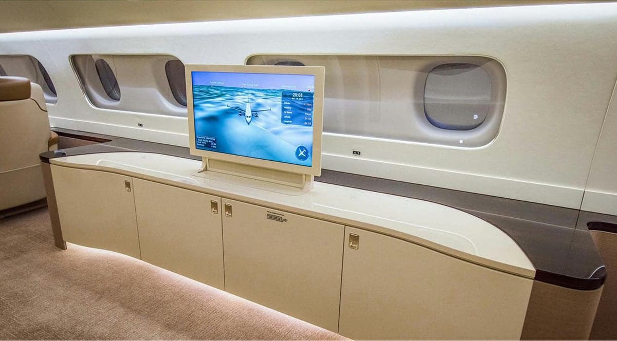 A view of the aircraft's interior, featuring a television screen and cabinets.