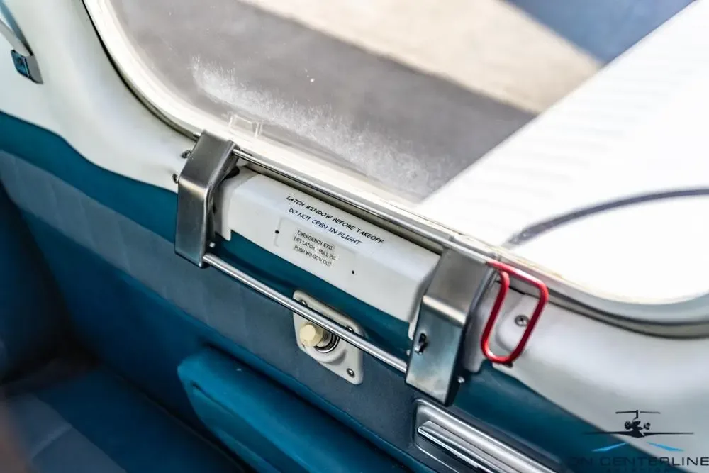 Close-up of the interior door and emergency exit instructions of the aircraft.