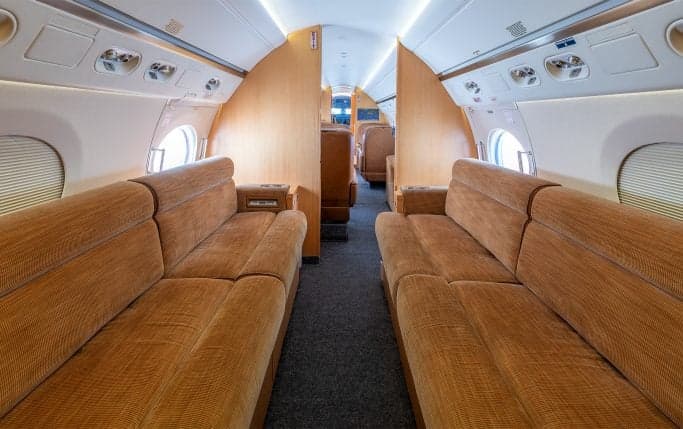 Aircraft lavatory interior with sink and cabinets.