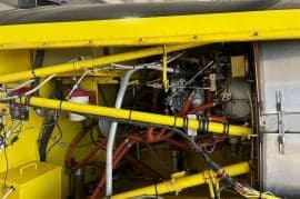 Close up of the engine compartment of a yellow Air Tractor aircraft.