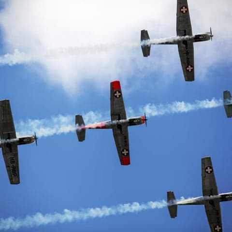Pilatus PC-7 aircraft HB-RBN in flight with Swiss flag on tail.
