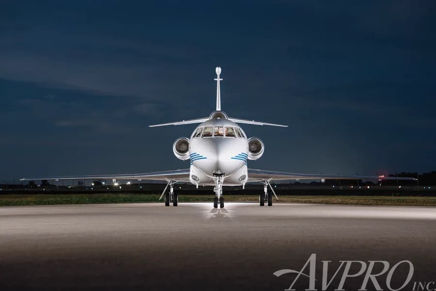 A head-on view of the Dassault Falcon 900EX, N917JF, parked on a tarmac at night.