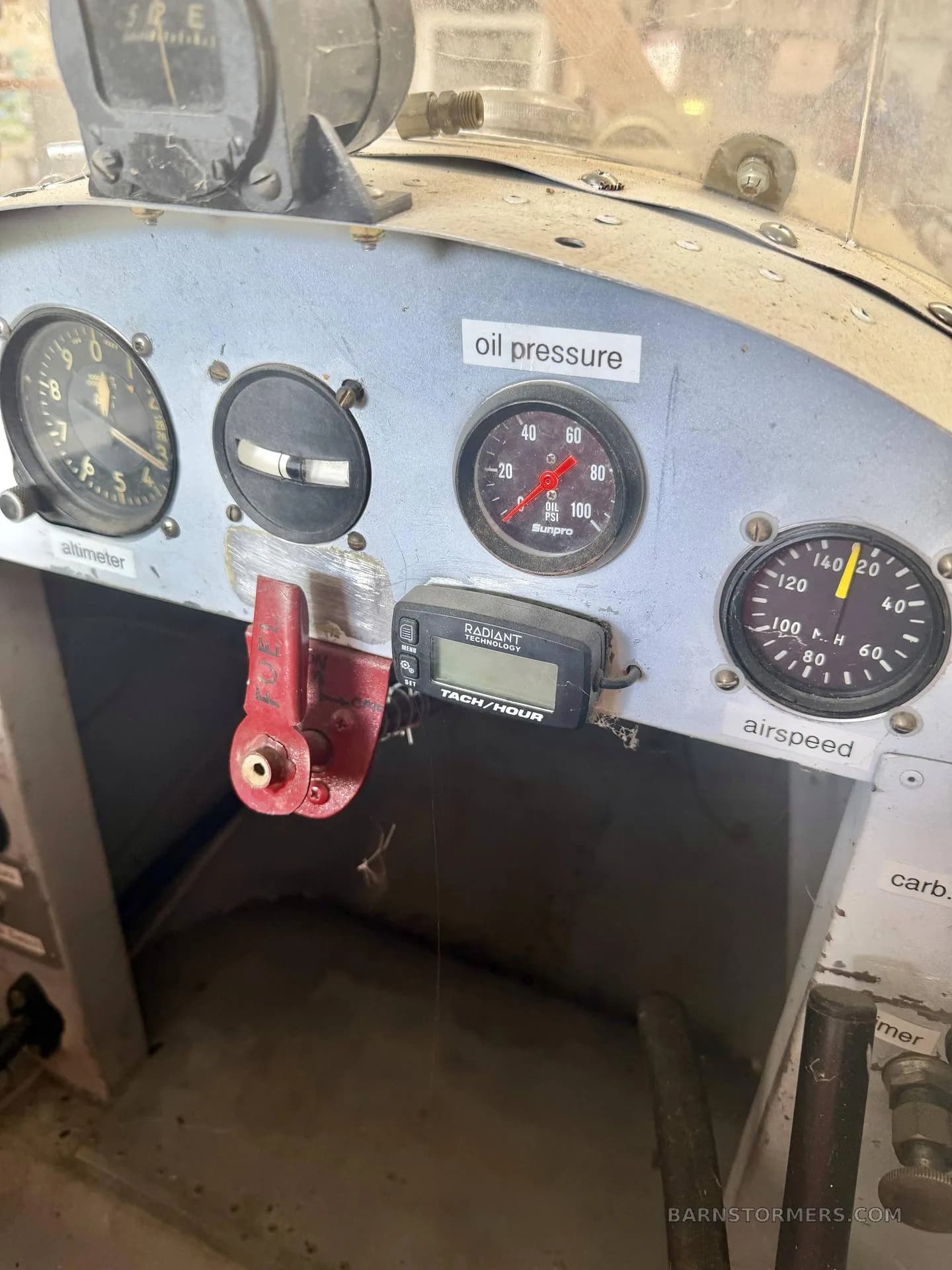 A close-up of the basic instrument panel of an experimental aircraft, showing gauges for altimeter, oil pressure, and airspeed.