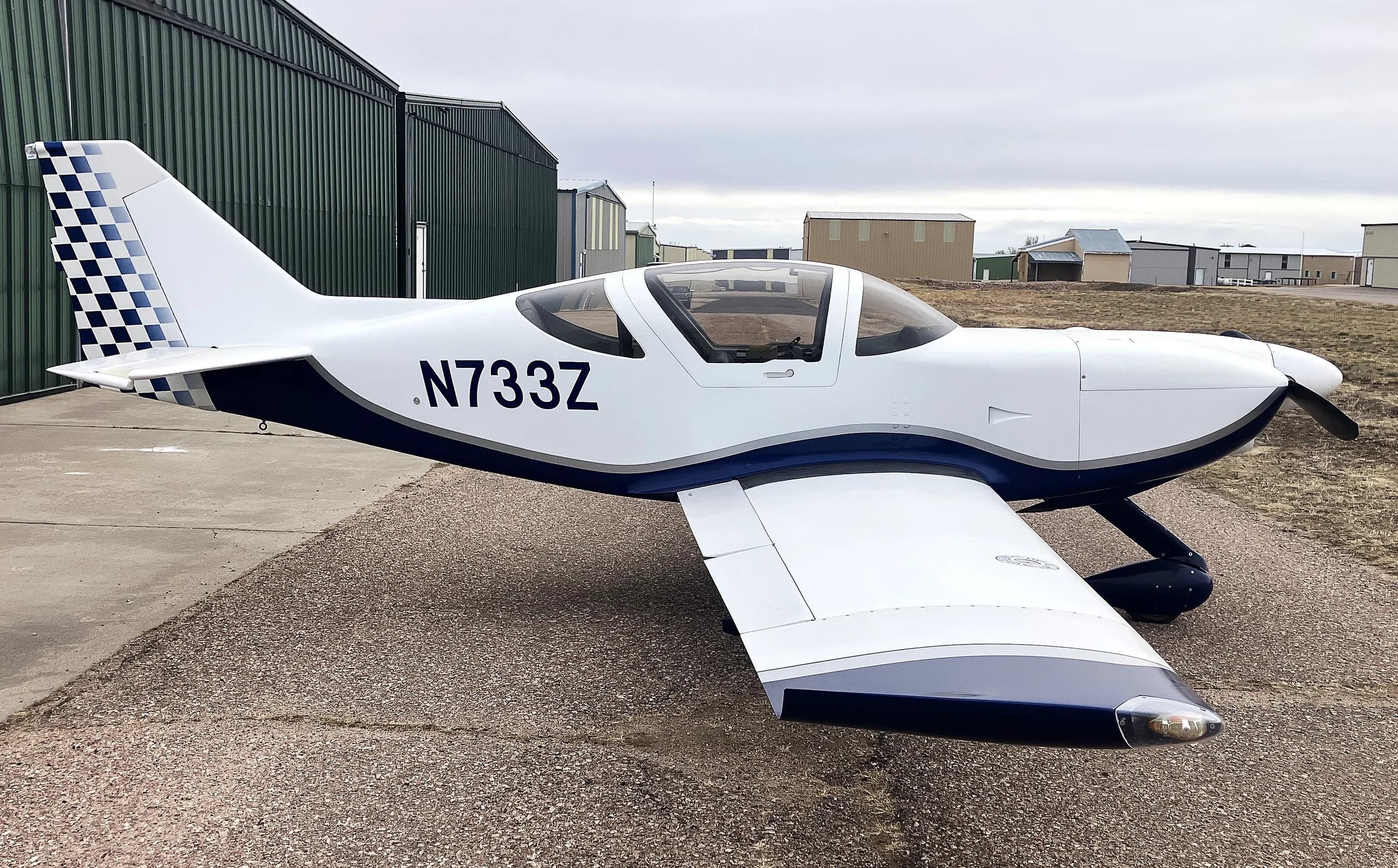 A white and blue Glasair Sportsman aircraft (N733Z) parked on an airfield, viewed from the front-right side.