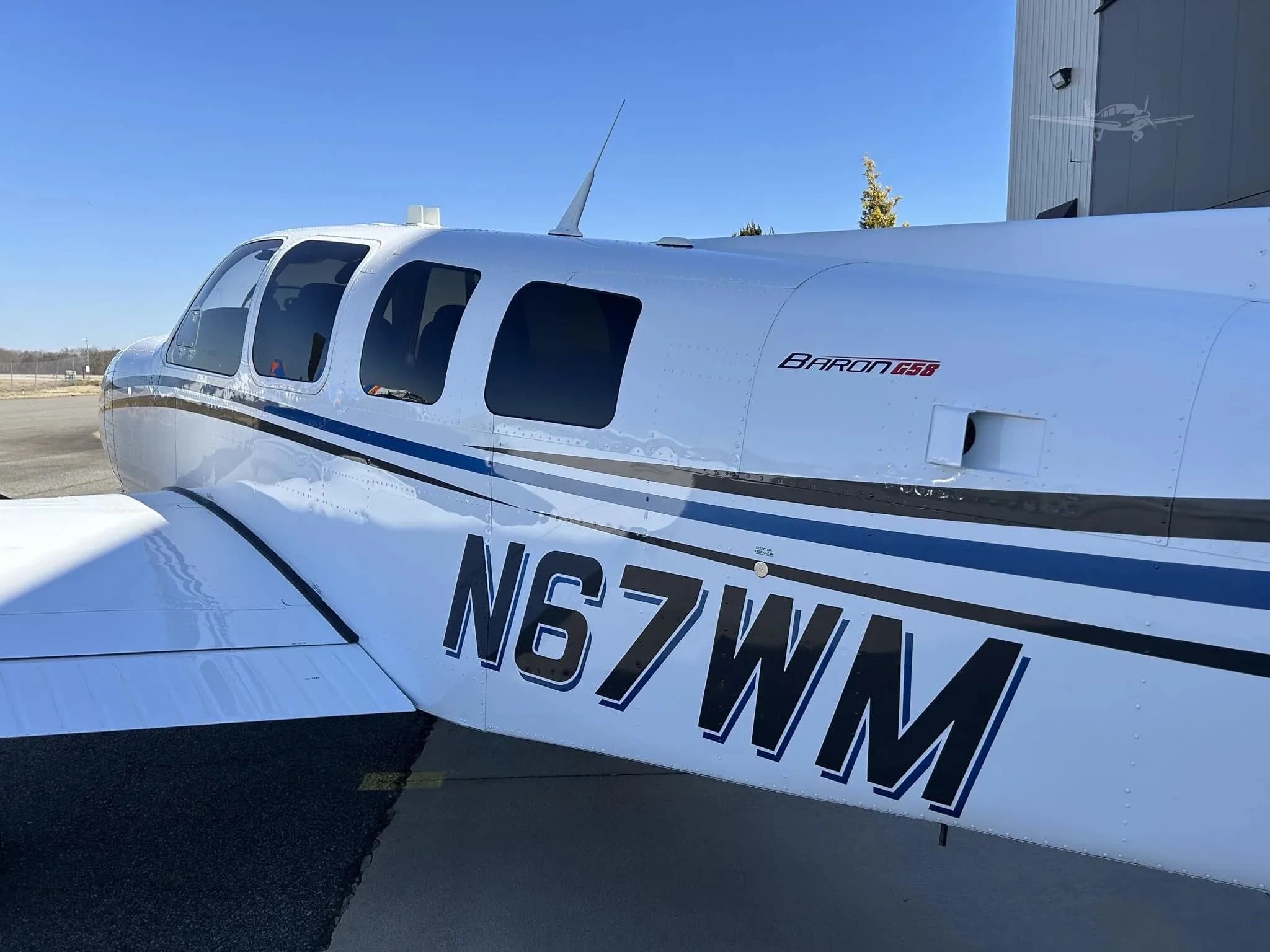 A close-up side view of the fuselage of Beechcraft Baron N67WM, showing the tail number and 'Baron G58' text.