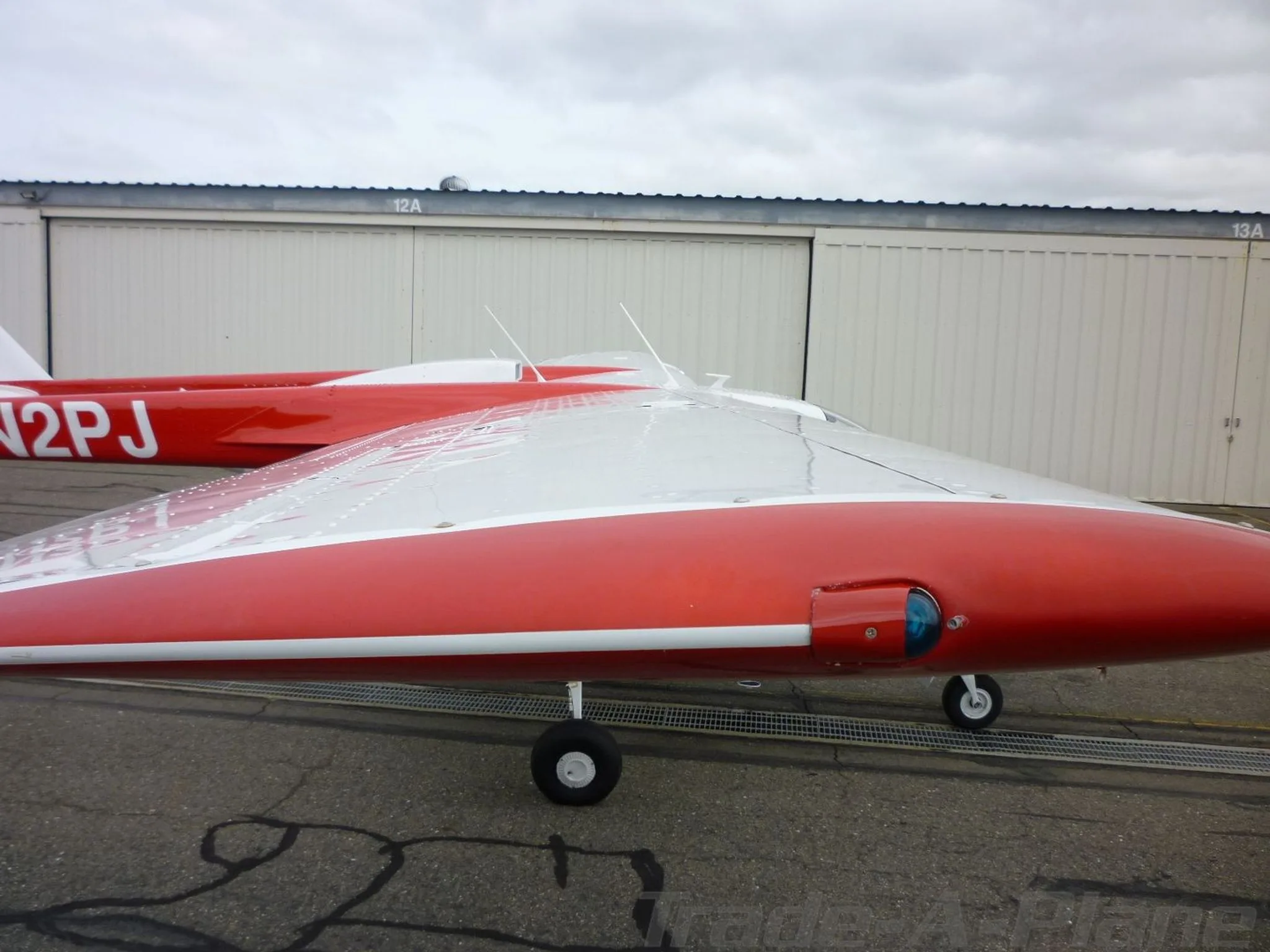 A close-up view of the red and white wing and fuselage of the Cessna Skymaster N2PJ.