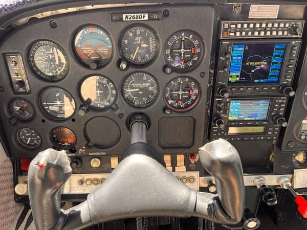 The cockpit of the aircraft N2680F shows the instrument panel and control yoke.