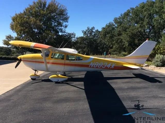 N8834X Cessna 172 Skyhawk with yellow and orange paint scheme, side view.