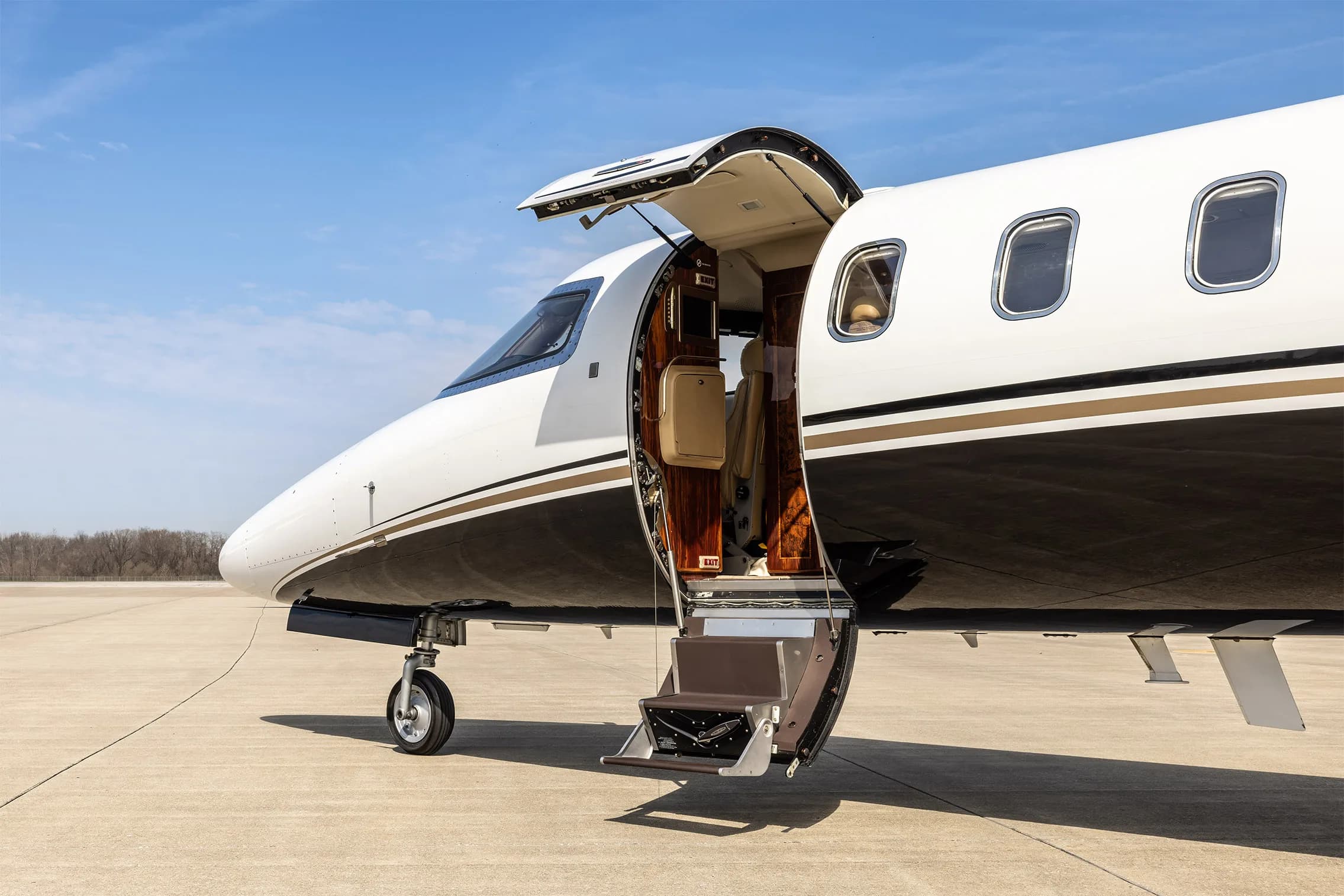 A close-up view of the open main cabin door and extended stairs of a Learjet 60 business jet.