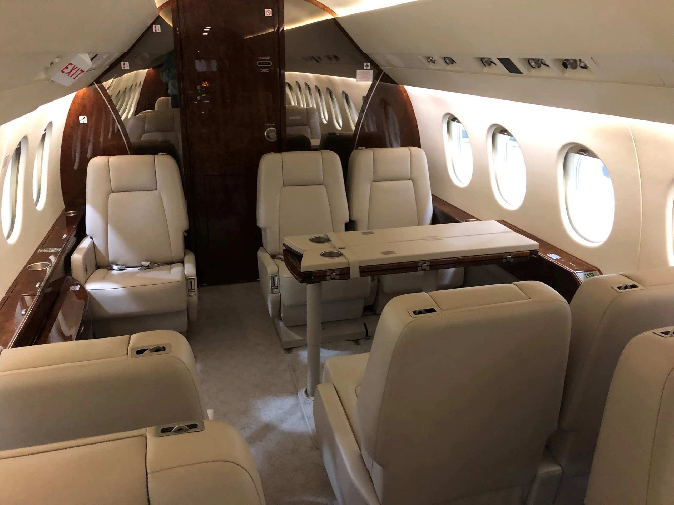 The aircraft's interior features cream-colored leather seats and a table.