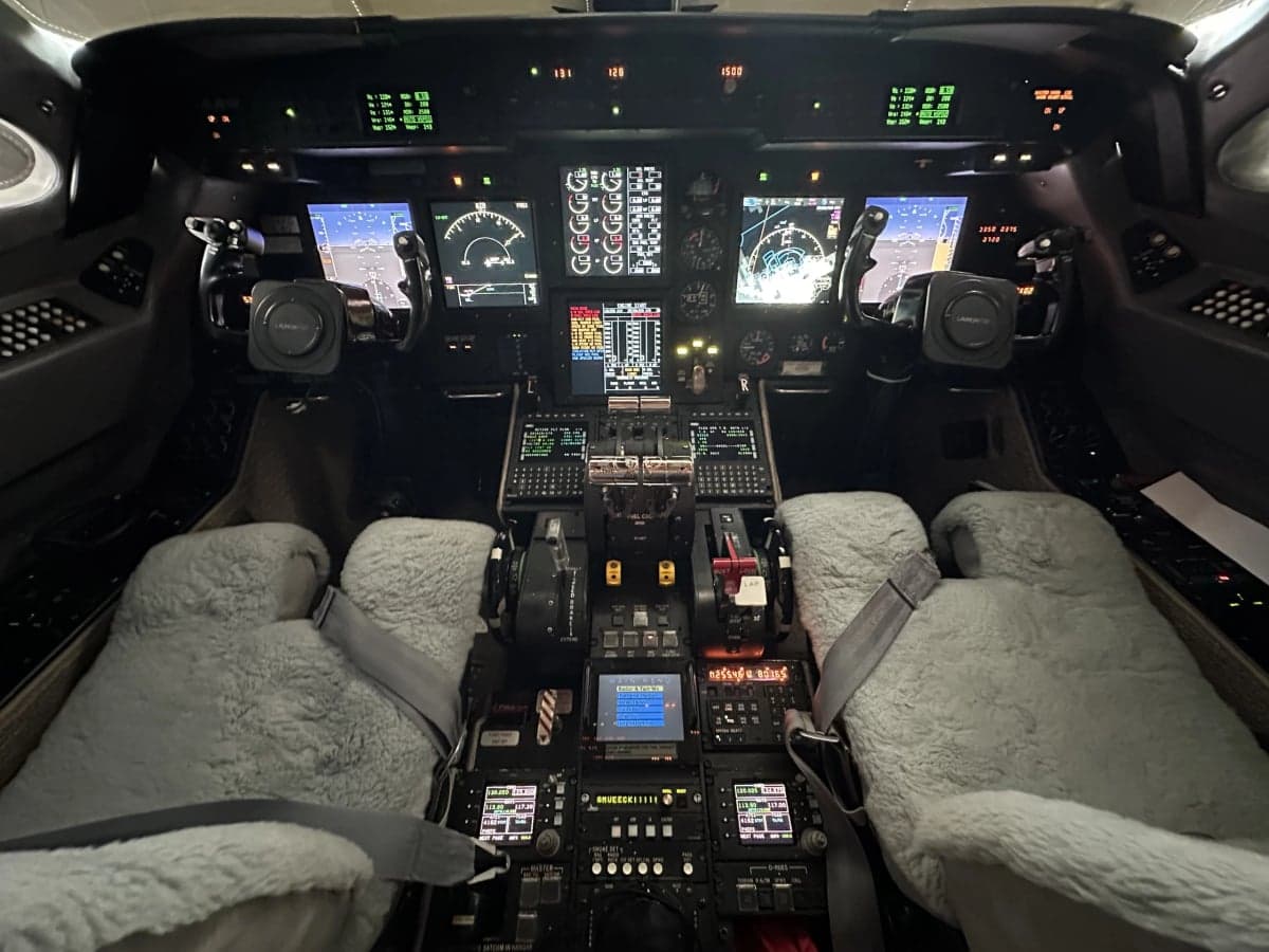 The aircraft cockpit with instrument panel and sheepskin seat covers.