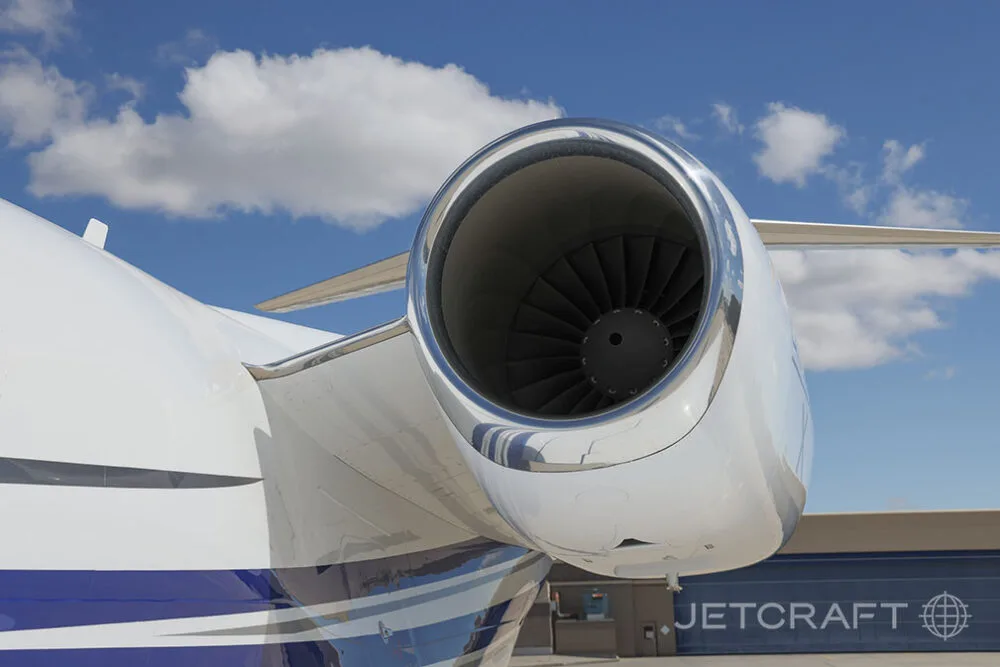 A close-up view of the polished engine intake of a Cessna Citation X jet against a blue sky.