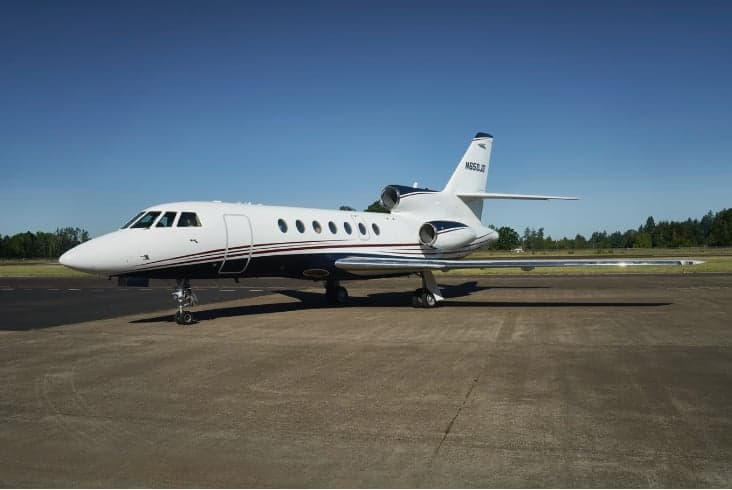 A Falcon 900EX EASy aircraft with registration N955JG parked on the tarmac.
