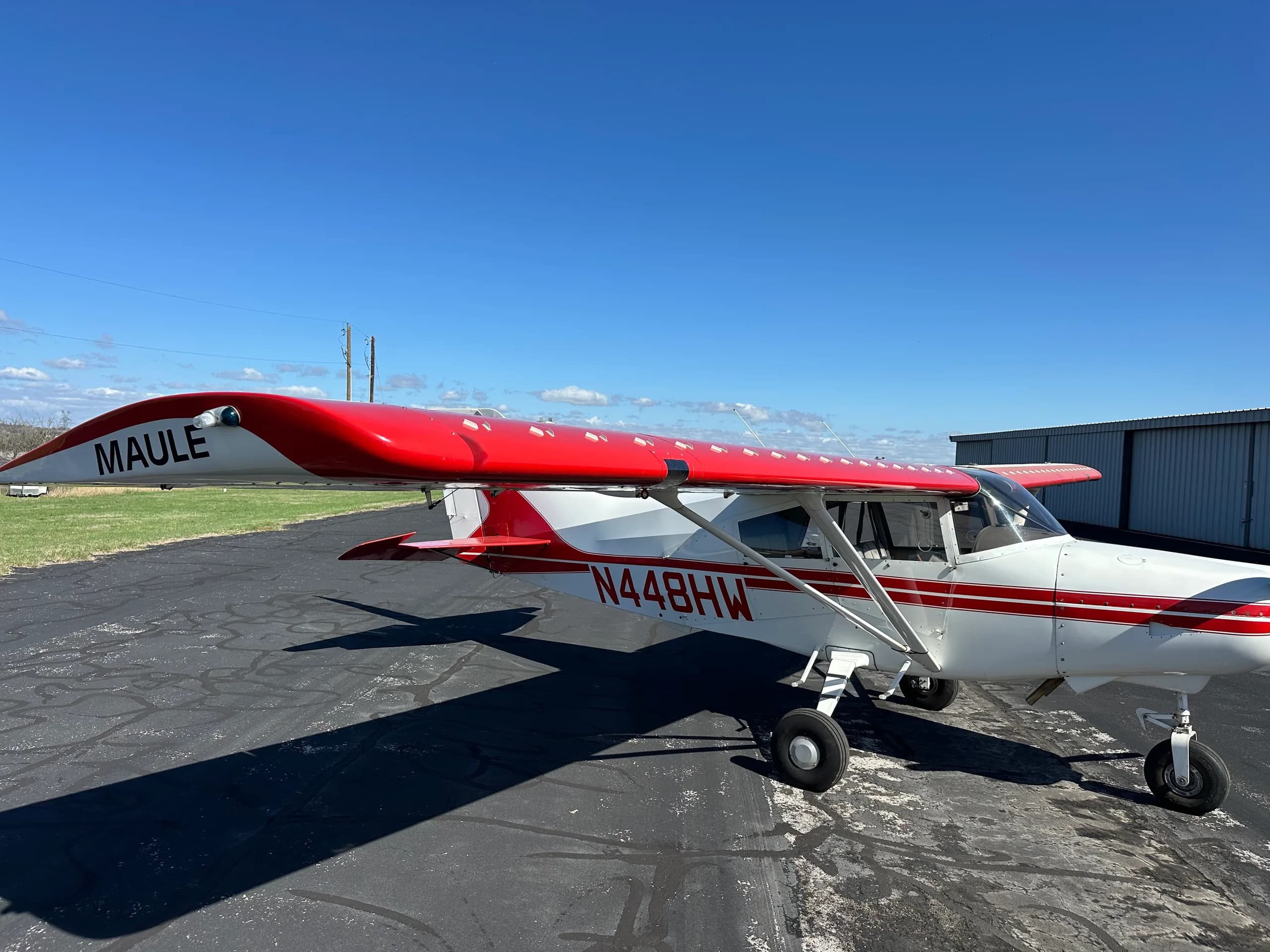 A Maute aircraft with red and white paint scheme is parked on the tarmac.