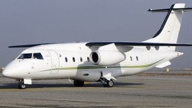 Side view of a white British Aerospace 146 aircraft on the tarmac.
