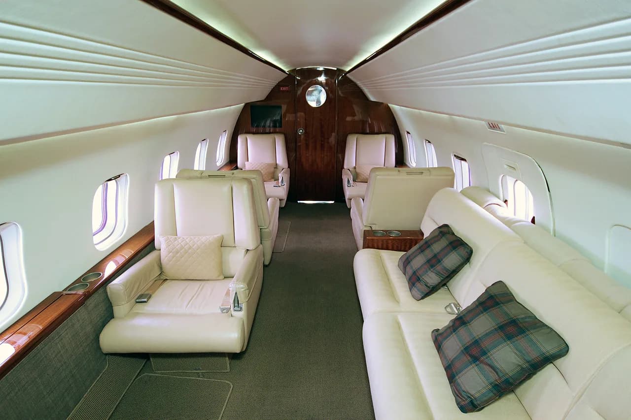 Interior view of the Challenger aircraft cabin with white leather seats.