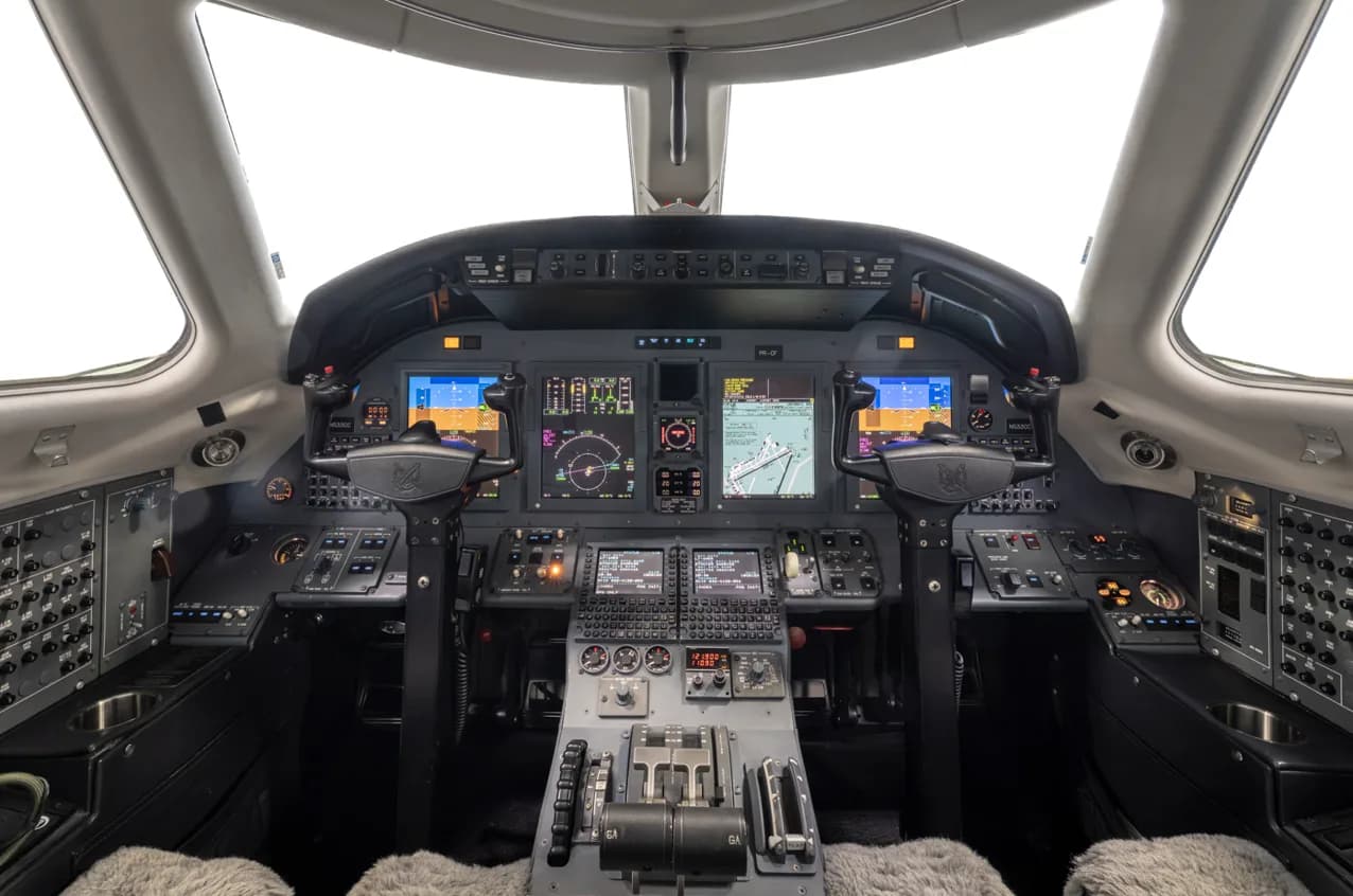 The cockpit of a Cessna Citation jet, featuring multiple digital displays and a complex instrument panel.