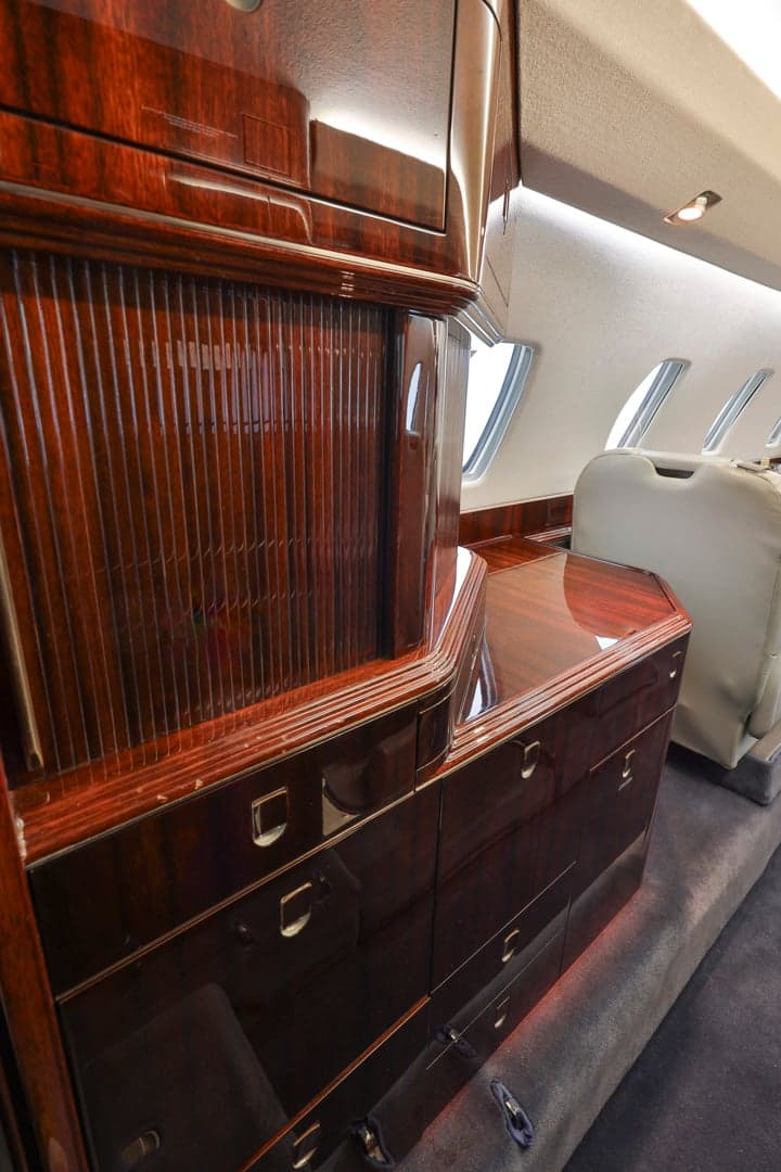 A close-up of the wood trim and cabinetry inside a Citation CJ3 aircraft.