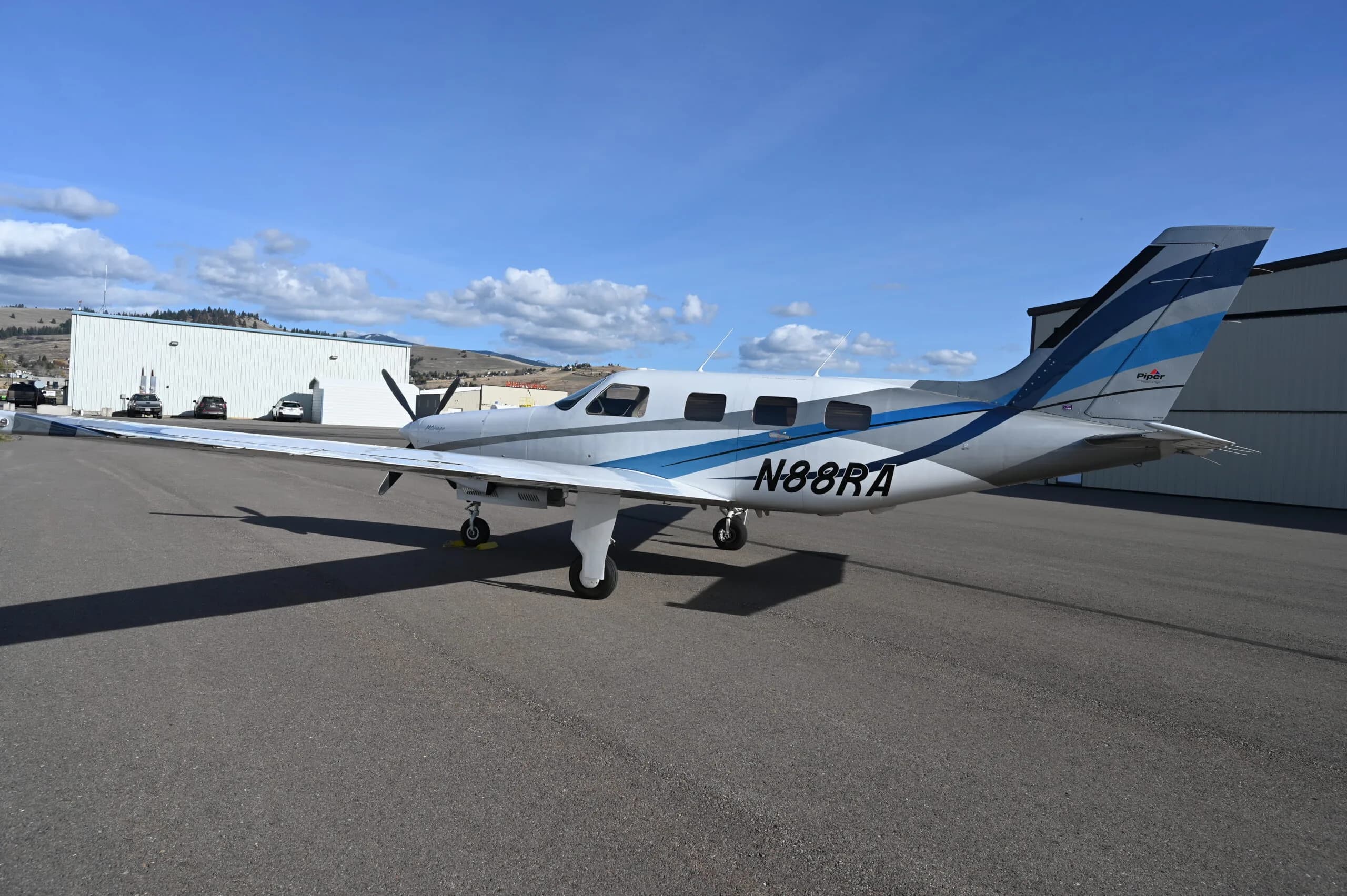 Piper Mirage N88RA parked on the tarmac in front of a hangar.