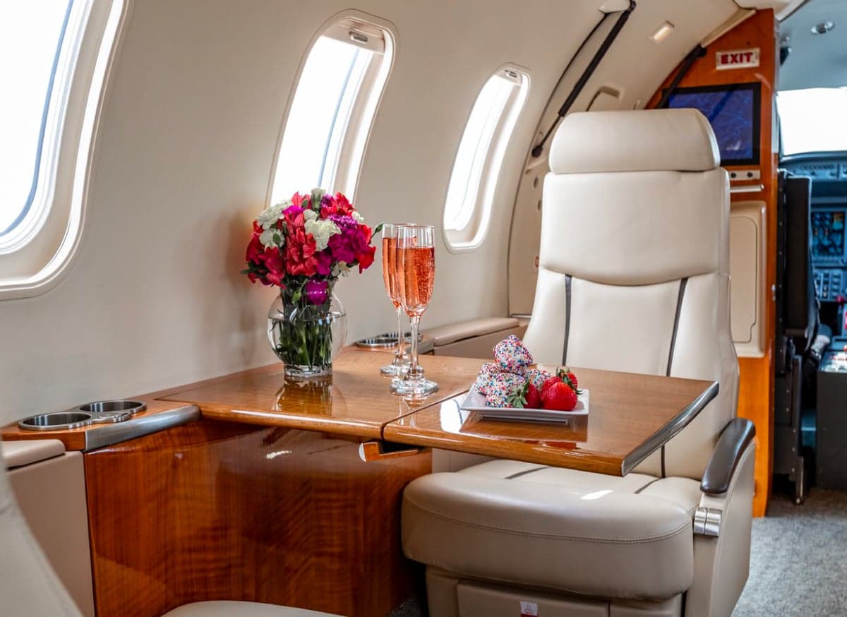 Interior of the aircraft with a table set with flowers, drinks, and snacks.