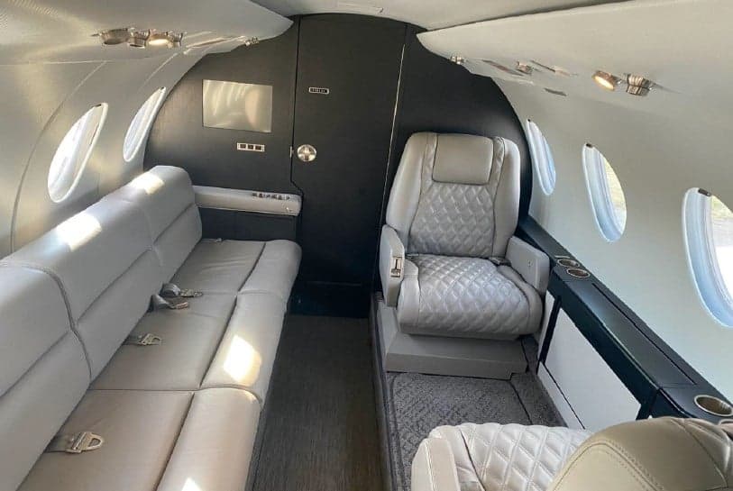 Cabin interior with seating and entertainment screen.