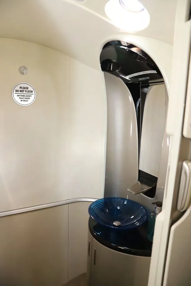 The lavatory of a HondaJet Elite S, featuring a modern sink with a blue glass bowl.