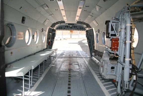 The interior of a helicopter with benches and equipment.